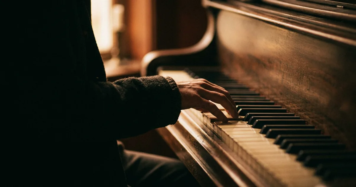 A hand playing a single note on a piano while shaping a melody's contour