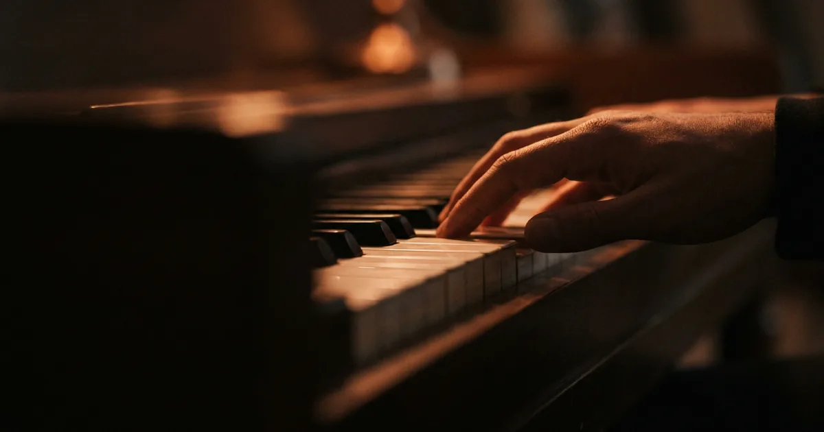A hand playing the royal road progression on piano keys in warm light, four chords of the IV-V-iii-vi loop