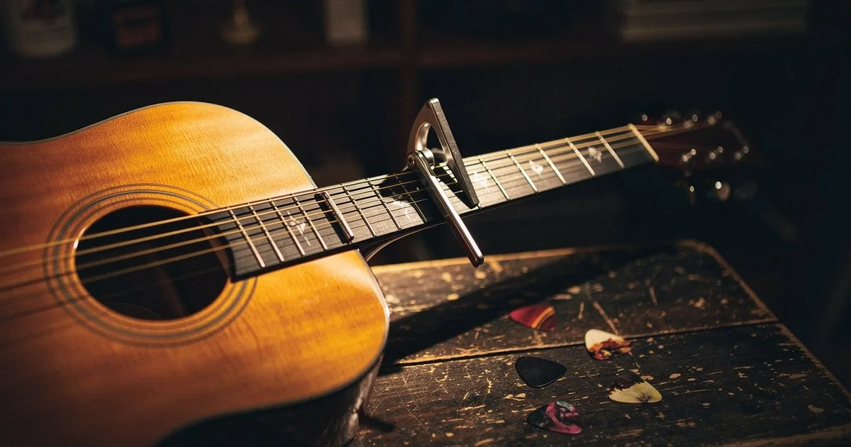 An acoustic guitar with a capo clamped on its neck, the physical version of transposing a song to a new key, which is the core idea behind the Nashville Number System.